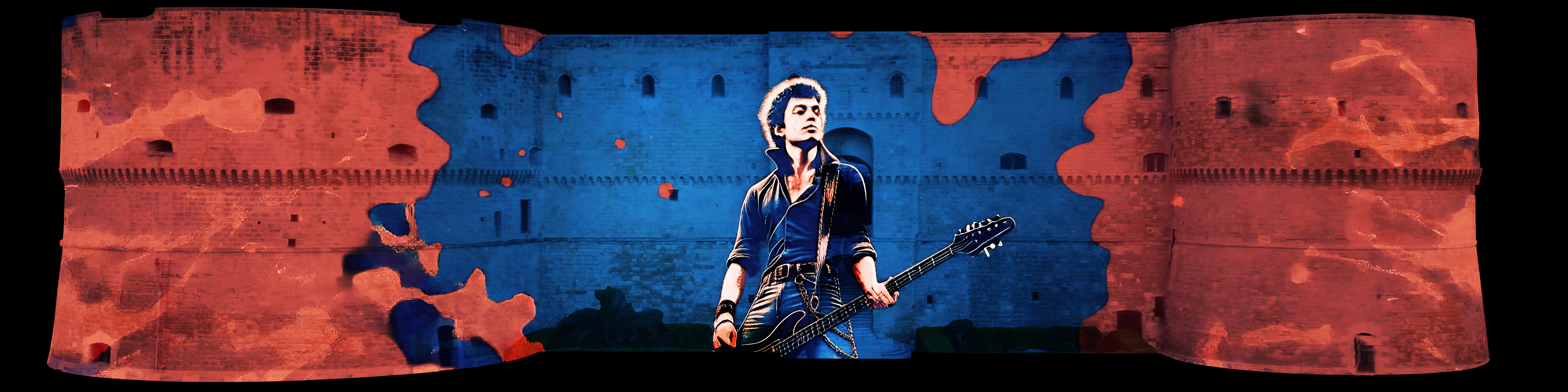 Paul Simonon con il basso su un fondale astratto rosso e blu